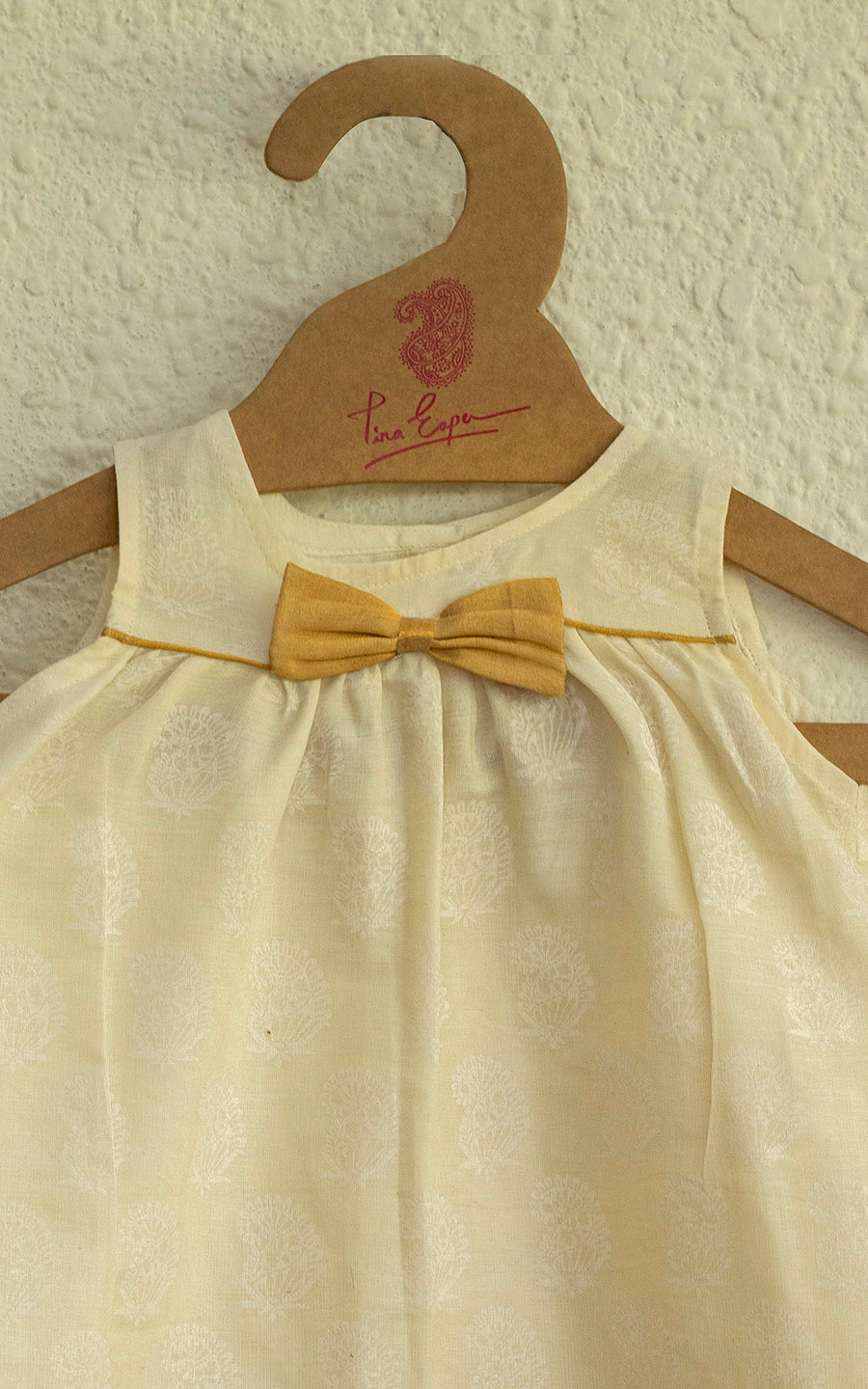 A CHARMING HAND BLOCK PRINTED VINTAGE ONAM DRESS WITH A KASAVY BOW IN PURE COTTON